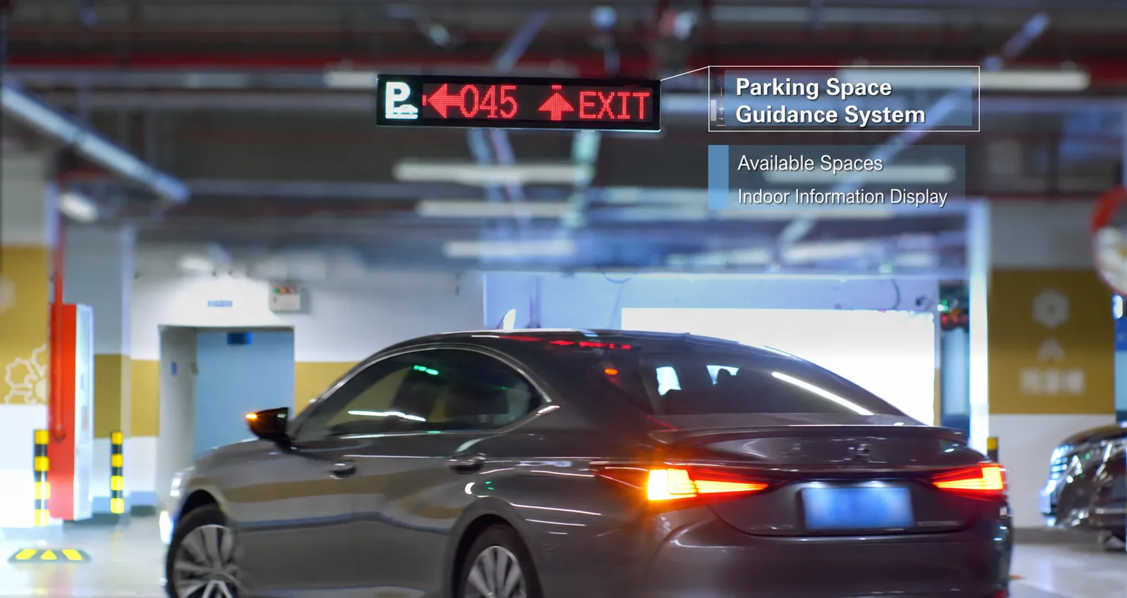 Indoor parking guidance display showing available spaces and an exit direction at a garage decision point