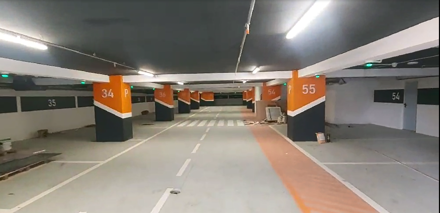 Installation-stage photograph of the Art Building car park, with green indicators and numbered bays.