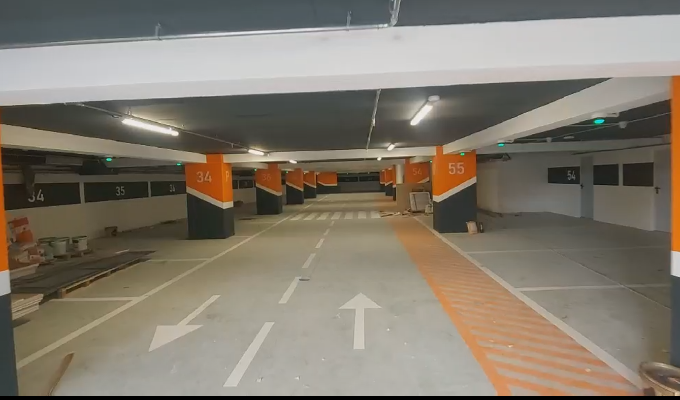 A second installation view shows the parking aisle and the pedestrian crossing.